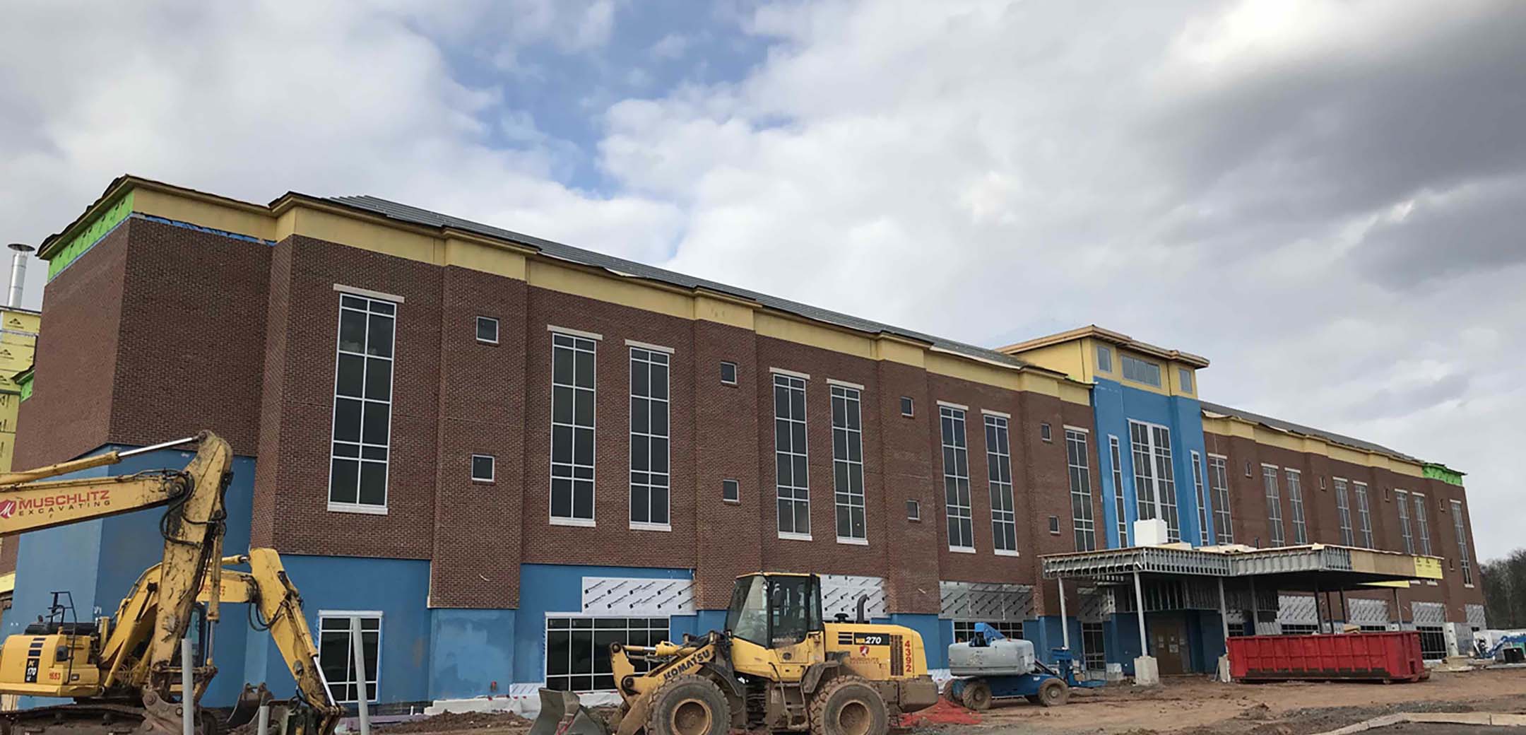An angled view of the St Luke's Quarter red brick building showcasing the insulation application and construction process.