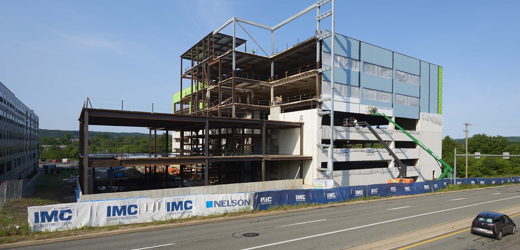 A view of the Main Line Health Center building showcasing the building during its construction phase, metal structure and insulation being applied.