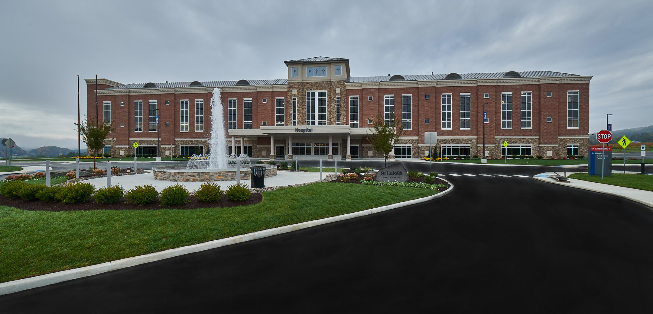 St. Luke' s Carbon County hospital showcasing the 3-story building and both the main, emergency entrances, and the fountain in front.