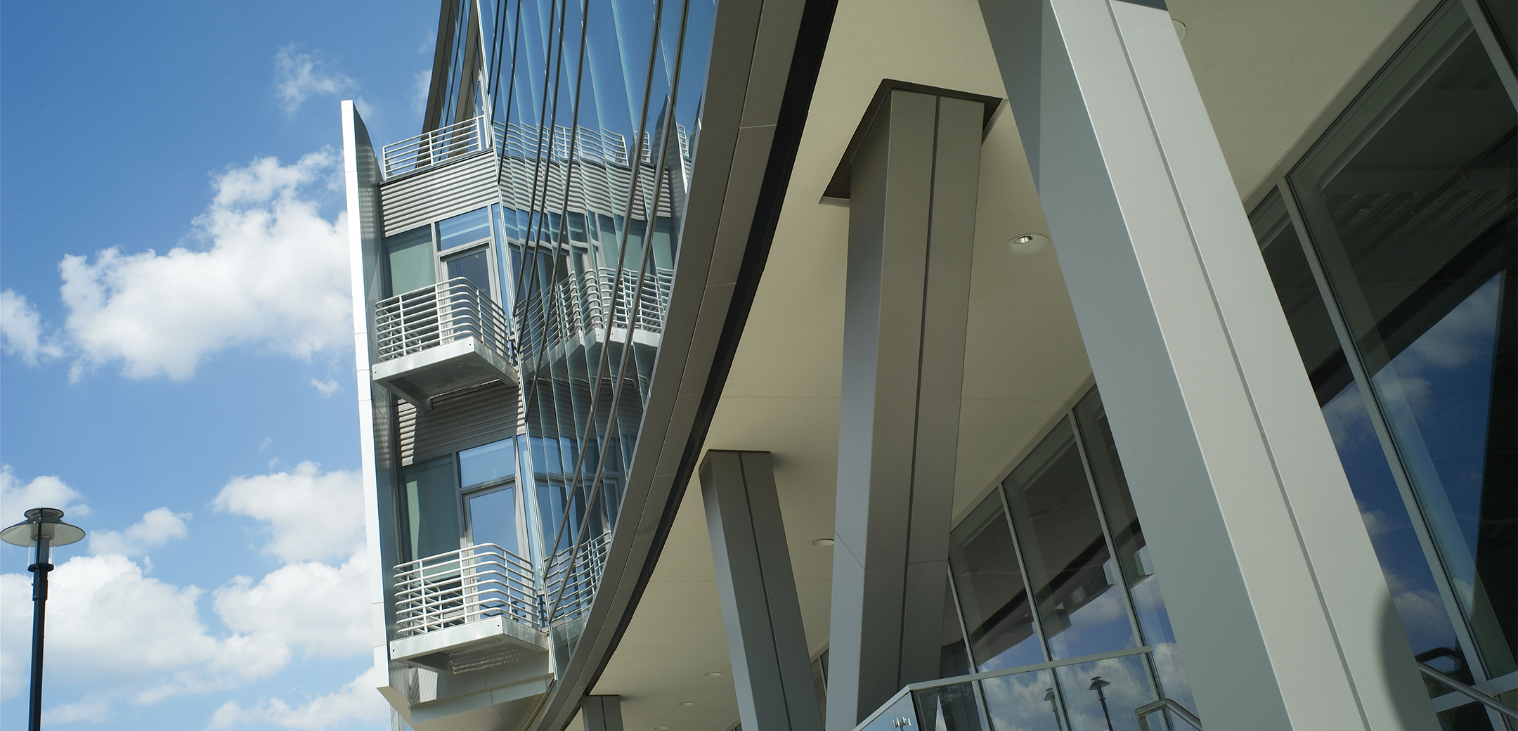 A close up of the overhang feature of the entrance showcasing the balcony in the extruded section of the glass front of the Tasty Baking company headquarters.