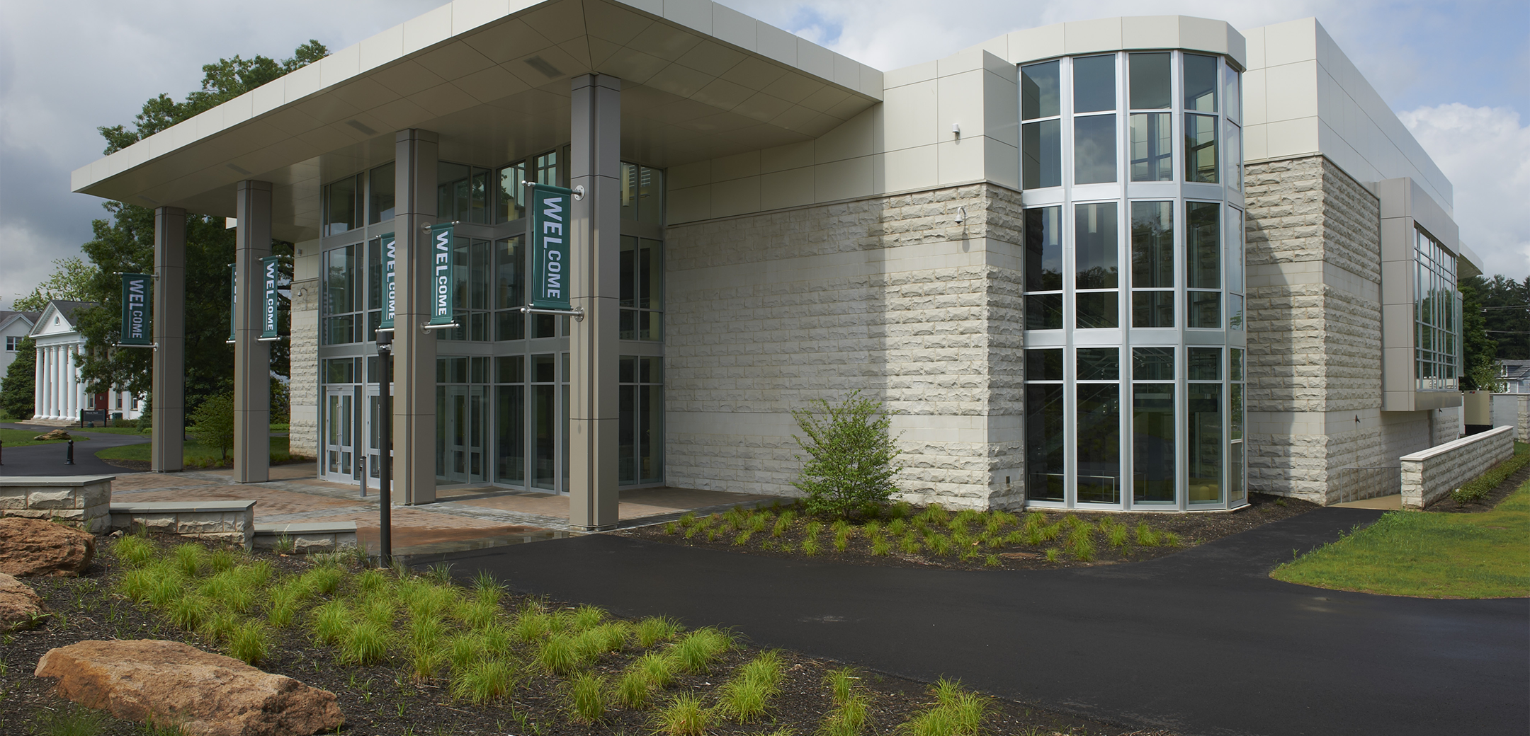 A close up view of the Delaware Valley College showcasing the rounded, floor to ceiling glass corner design and glass front entrance.