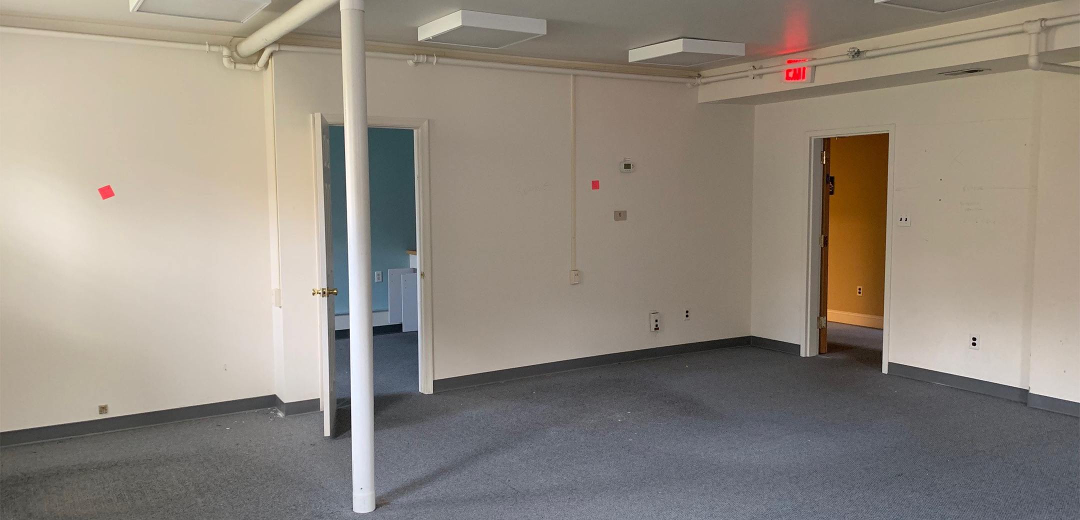 An empty room of Philadelphia Integrative Psychiatry with gray carpets and white walls.