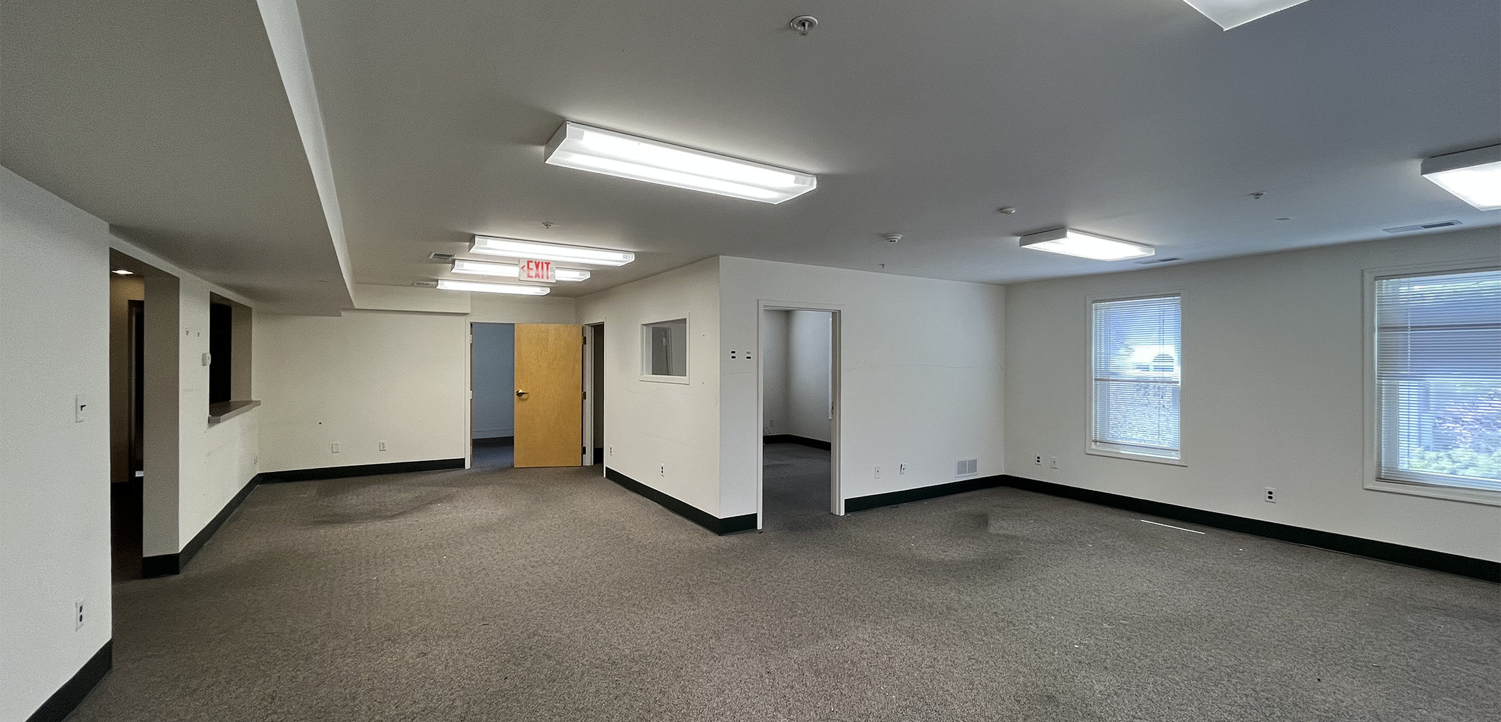 An empty room of Philadelphia Integrative Psychiatry with gray carpets and white walls.