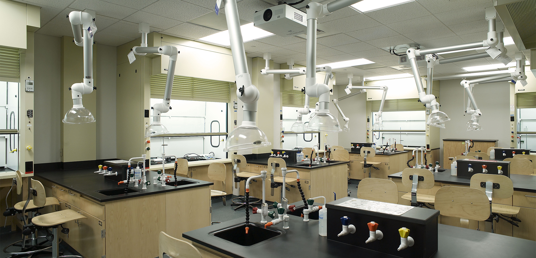 An interior view of the Stage x PA College lab , showcasing the workbenches with built in sinks and adjustable fume hood arms.