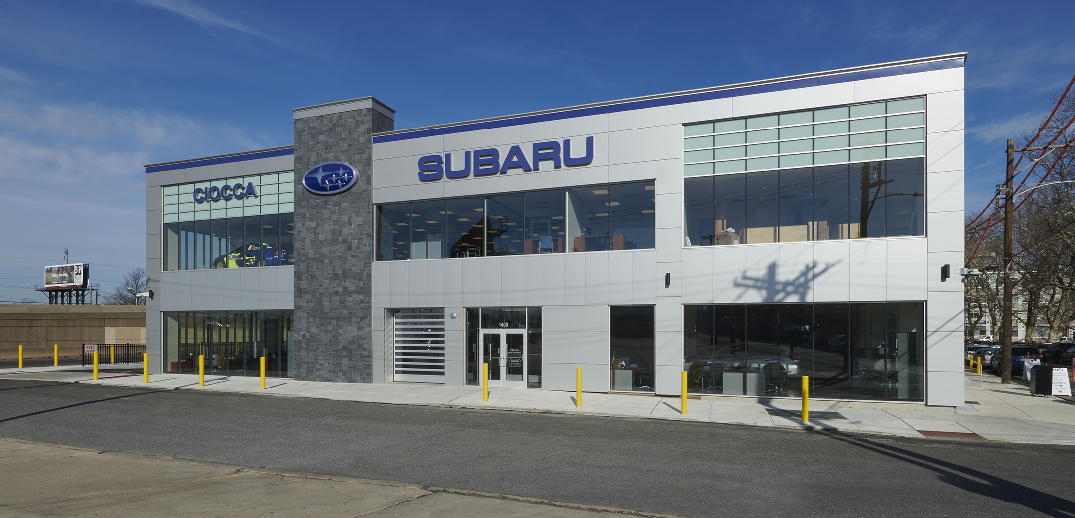 An exterior view of the Ciocca Subaru building showcasing the "Subaru" signage, logo, side street and front entrance door.