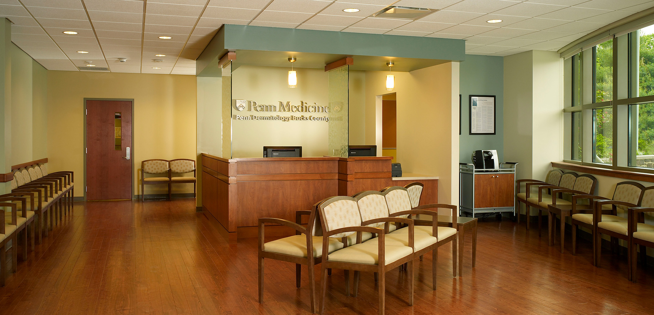 An empty lobby with chairs and a reception desk of Penn Medicine Dermatology office at Floral Vale Corporate Center.