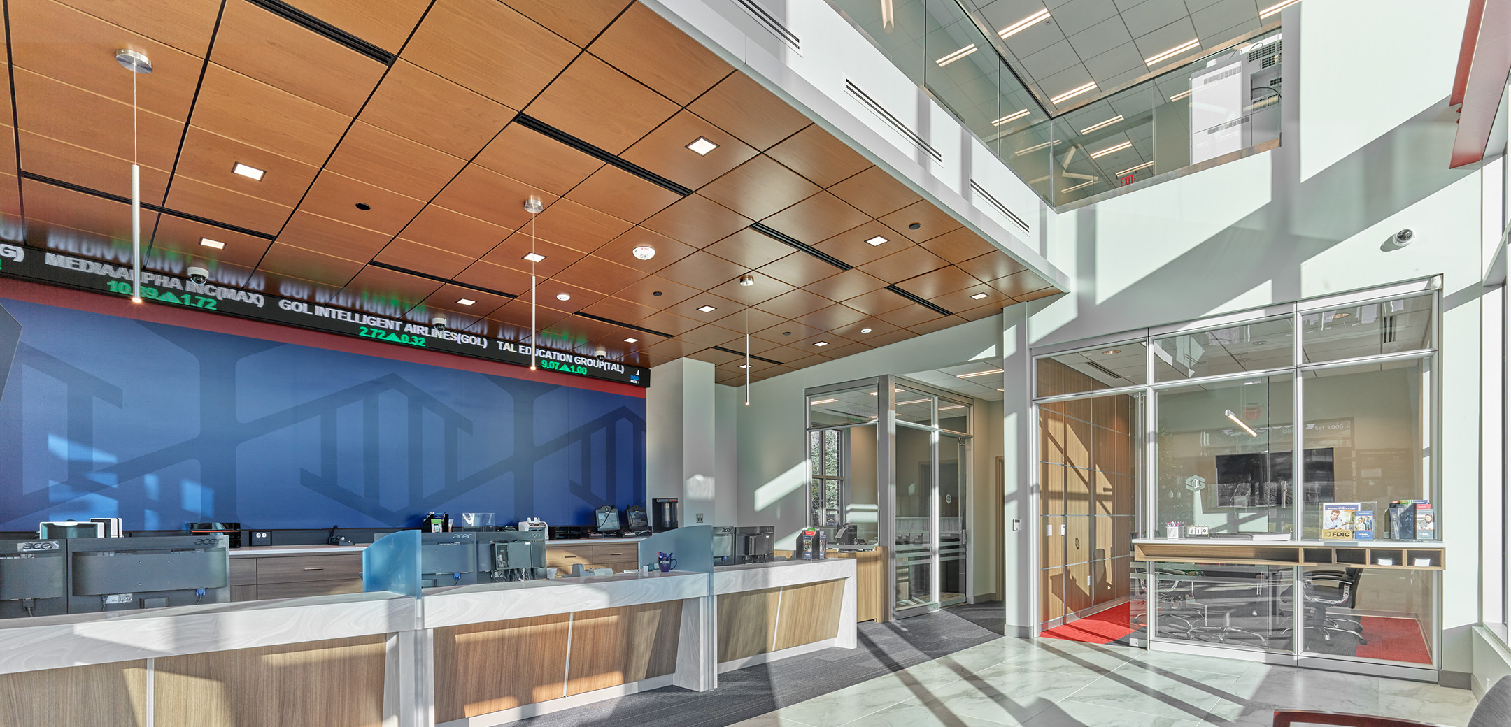 The interior of Peoples Security Bank featuring bright open space, a bank teller area with wood ceilings, and glass surrounding offices