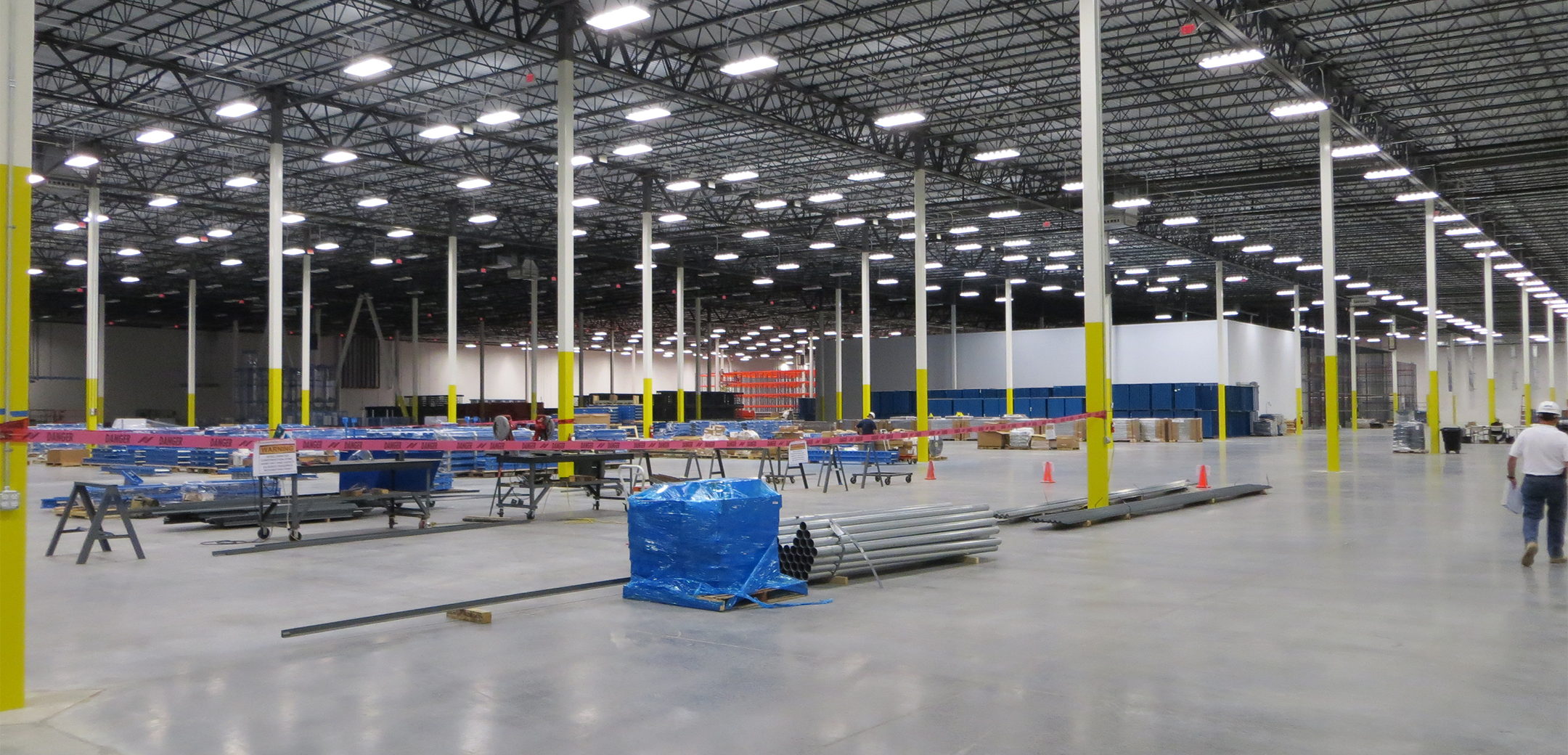 An interior view of the Project Liberty Distribution warehouse showcasing the inner length, support pillars and smooth concrete flooring during the assembly process.