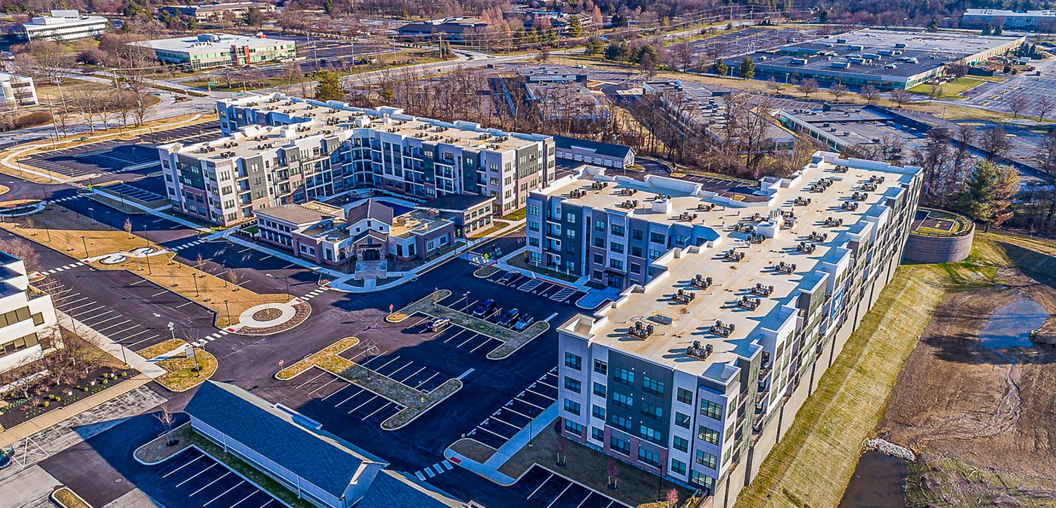 An aerial shot of the Sweadsford Square Apartments building, showcasing the large layout, parking amendments, and general area.