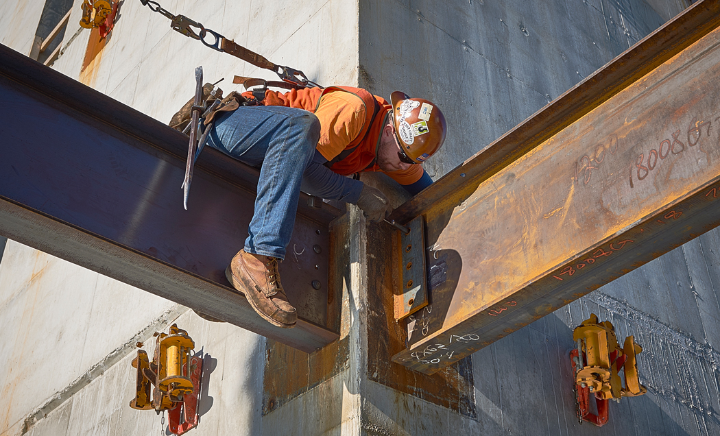 An IMC Construction worker fastens and iron beam to the Penn Medicine Center for Healthcare Technology.
