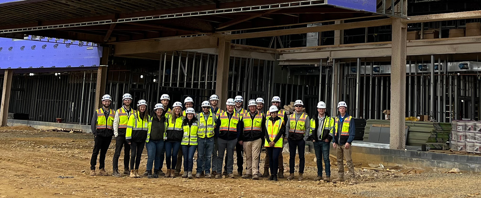 A group photo of IMC employees in hard hats and safety vests on a job site.